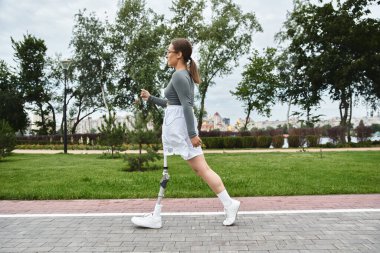 Spor giyim sektöründe kararlı genç bir kadın açık havada kendinden emin bir şekilde egzersiz yapıyor, gücünü ve canlılığını kucaklıyor..