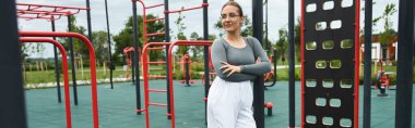 Genç bir kadın güneşli bir günü kucaklıyor, aktif bir park ortamında çalışıyor..