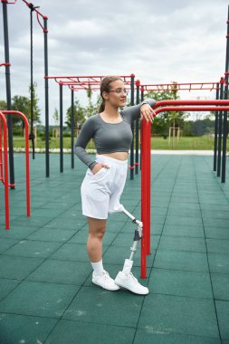 Kararlı genç bir kadın, protez bacağını kullanarak, açık havada spor yapmayı benimsiyor..