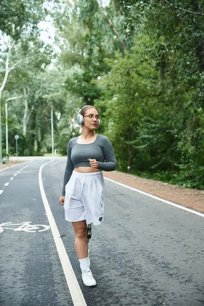 stock image A young woman in sportswear embraces her day outdoors while exercising with determination.