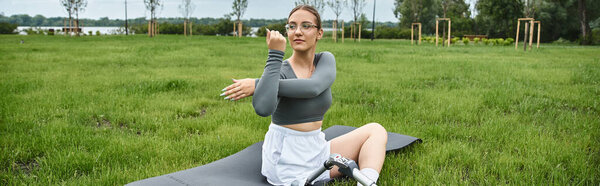 Молодая женщина в спортивной форме практики растяжения упражнения на открытом воздухе, охватывая фитнес и расширение прав и возможностей.
