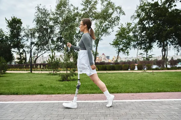 stock image A determined young woman in sportswear confidently exercises outdoors, embracing her strength and vitality.