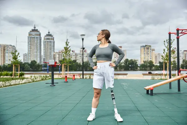 stock image A confident young woman in sportswear works out outdoors, embracing her strength and determination.