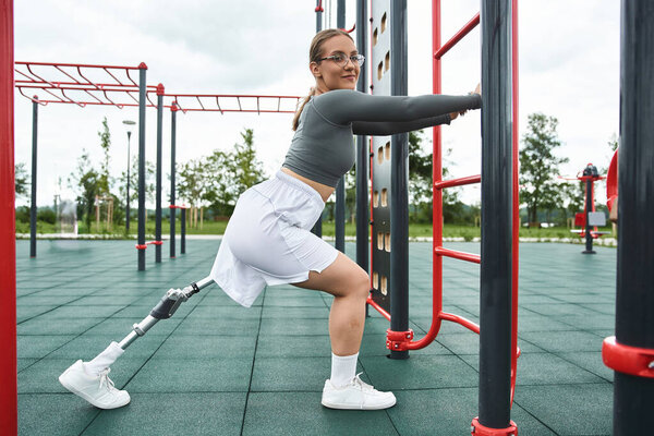 Решительная молодая женщина раздвигает границы во время тренировки в открытом фитнес-зале.