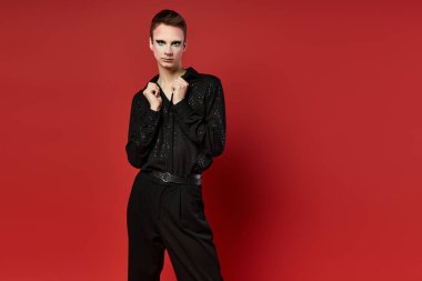 Hareketli genç bir travesti çekici bir poz ve şık bir kıyafetle büyülüyor..