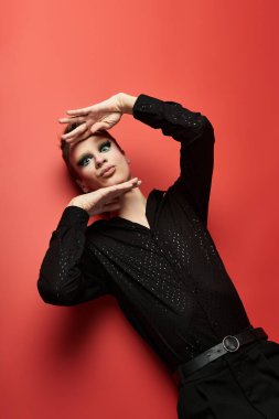 Canlı bir travesti, çarpıcı bir kıyafetle neşeli bir enerjiyle zarif poz verir..