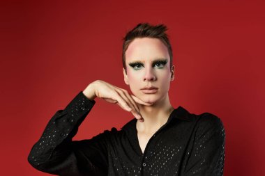 Genç bir travesti, dinamik pozlarla moda ve sanatı sergiliyor.