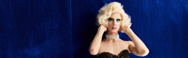 Genç bir travesti şık kıyafetlerini ve dinamik duruşunu sergiliyor..