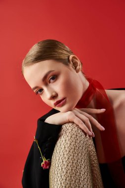 Güzel bir kadın çiçeklerle çevriliyken başını nazikçe uzatır..