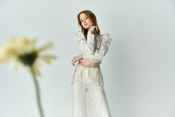 A beautiful young woman showcases her elegance surrounded by flowers.