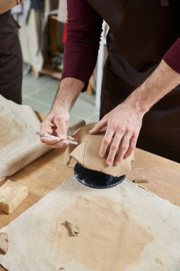 İyi aydınlatılmış stüdyoda çömlek yapan sanatçı bir adam..