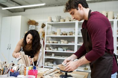 A couple enjoys crafting pottery together, immersed in creativity and connection. clipart