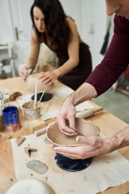 A couple joyfully crafts pottery together in a modern studio. clipart