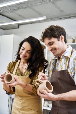 A couple joyfully shapes clay into beautiful pottery together. clipart