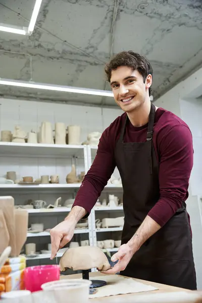 stock image Delighted man in apron making pottery.