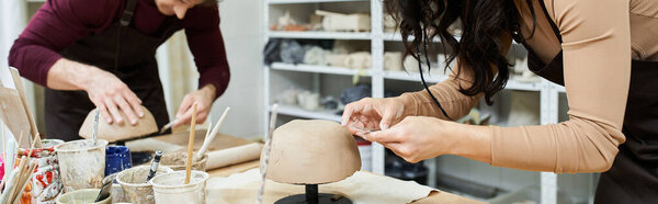A couple passionately shapes clay together, enjoying the art of pottery.