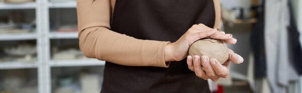 Talented sophisticated woman with apron making pottery.