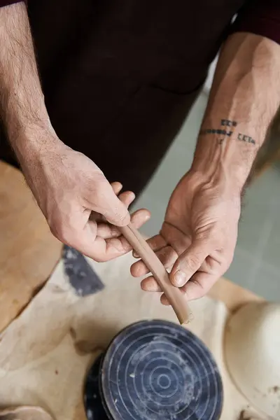 stock image Devoted stylish man in apron making some pottery in studio.