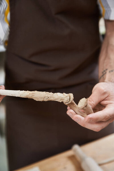 Young man making pottery in studio.