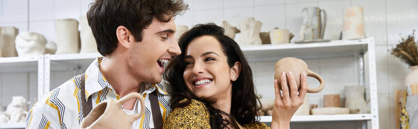 A couple joyfully molds clay in their creative pottery studio.