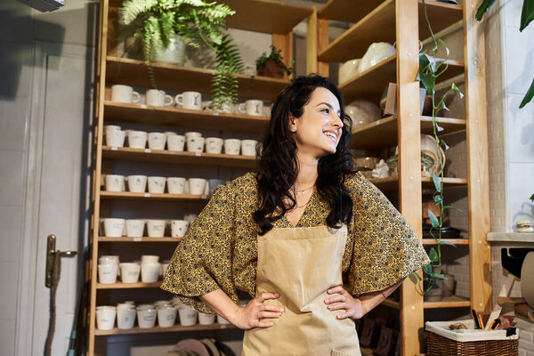 Jolly brunette woman posing in pottery studio.