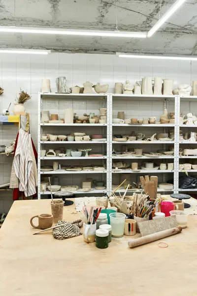 stock image Roomy pottery studio with table and pots.