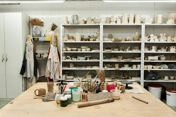 stock image Comfortable pottery studio with table and pots.