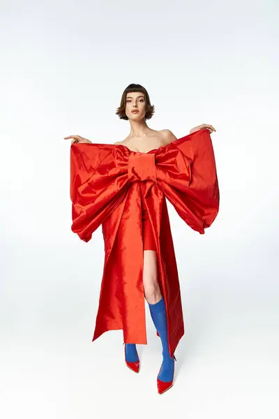 stock image A young woman showcases her fashion forward look in vibrant red attire.