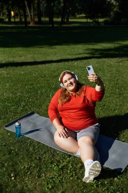 Neşeli bir kadın dışarıda egzersiz yapıyor, spor yolculuğunu yakalıyor..