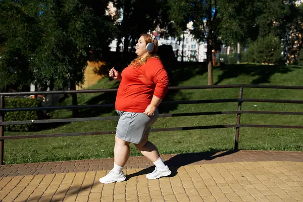 stock image Woman enjoys a refreshing workout while strolling through a vibrant park.