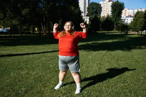 stock image A happy woman enjoys her fitness routine outdoors, embracing the warm sun and fresh air.