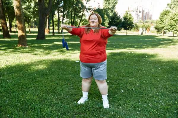 stock image A confident woman exercises with jump rope in a lush green setting.