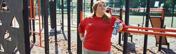 stock image A vibrant plus size woman takes a break while exercising outdoors.