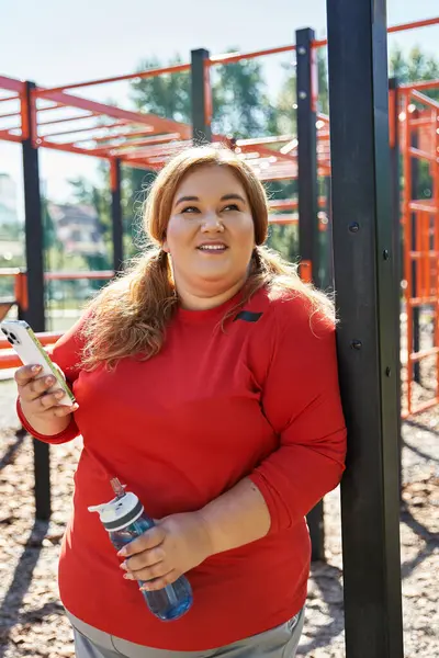 stock image A joyful woman engages in outdoor exercise with her water bottle in hand.