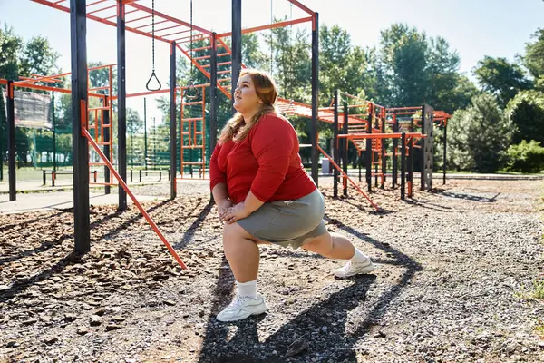 stock image A confident woman stretches in a park, enjoying her workout under the sun.