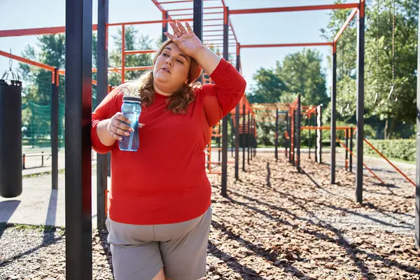 stock image A woman takes a break, enjoying nature after exercising outdoors.