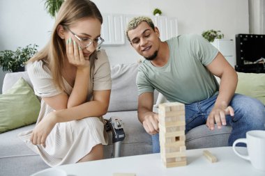 İki arkadaş rahat bir koltukta Jenga oynuyorlar..