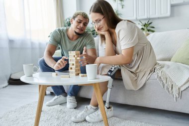Arkadaşlar içeride Jenga oynarken kahkahalarını paylaşıyorlar..