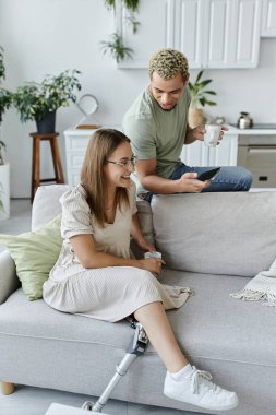 Arkadaşlar rahat, modern bir yaşam alanında dinlenirken bir ışık anı paylaşırlar..