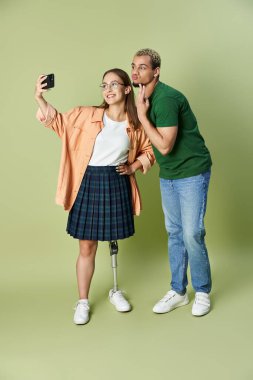 Arkadaşlar, yeşil bir arkaplana karşı neşeli bir selfie için birlikte poz verirler..