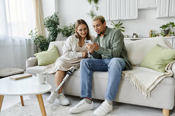 Two friends share laughter while looking at a phone in a cozy setting.