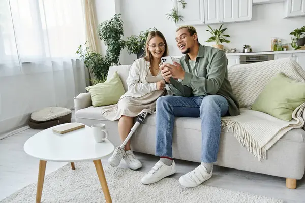 stock image Friends share laughter while exploring a phone together on a comfortable couch.