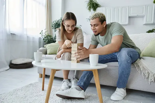 stock image Two friends engaged in a fun jenga game on a sunny afternoon.