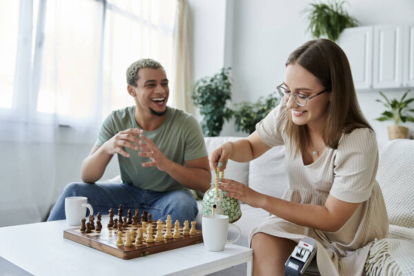 Двое друзей смеются и играют в шахматы, наливая чай в расслабленный день.