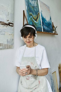 Tutkulu bir ressam sanat stüdyosunda müzik dinler..