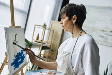 Bir kadın tuvaline dikkatle odaklanır ve canlı bir sanat eseri yaratır..
