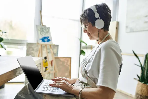 Stock image A woman engages with her creative process in a sunny art studio.