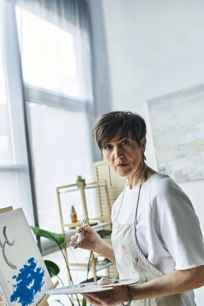 stock image A dedicated painter captures inspiration in her airy art studio.