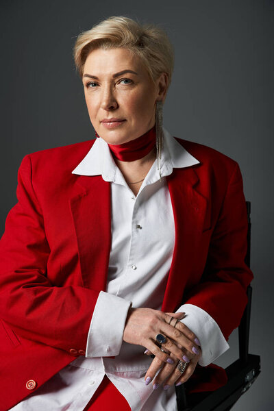 Взрослая женщина демонстрирует свое чувство стиля, излучая уверенность в поразительном красном наряде.