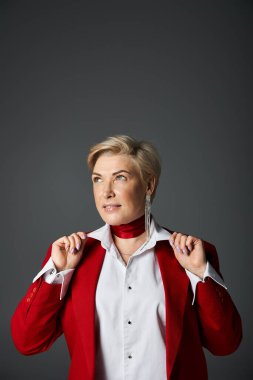Kendine güveni olan şık bir kadın ceketini sofistike bir ortamda ayarlar..